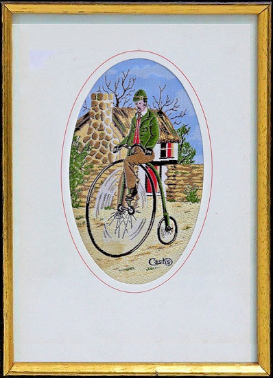 J & J Cash small oval centred woven picture with image of a man on a penny farthing cycle