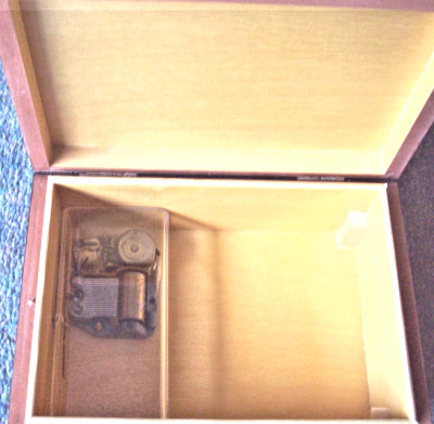 inside view of J & J Cash wooden musical box, showing the musical mechanism