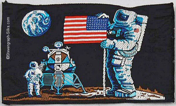 Dark blue silk, with images of two astronauts and moon lander, holding the American Stars & Stripes flag