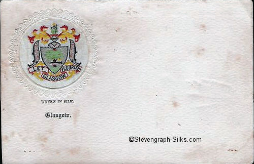 postcard with small circular woven silk depicting the Glasgow Coat of Arms