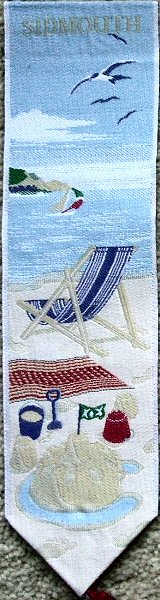 Cash's woven bookmark with woven title and view of a seaside beach