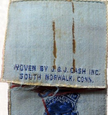 view of J & J Cash name woven on the reverse top turnover of this bookmark