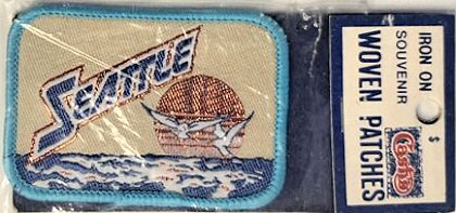 J & J Cash woven saw-on label with words: Seattle, with sea birds