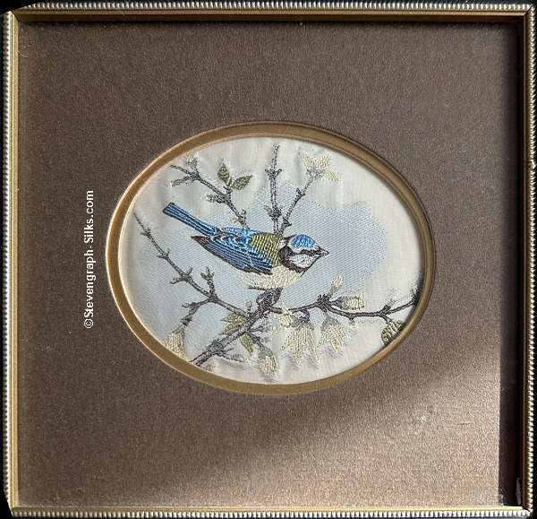 Framed woven picture of a bluetit, perched on a branch