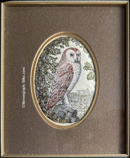 Framed woven picture of an owl stood on a rock, with a castle in the background