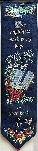 woven bookmark with words, May happiness mark every page in your book of life, and image of an open book