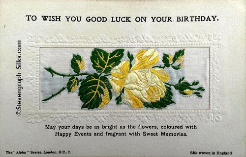 Alpha series postcard with no woven words, just image of a single rose and rose bud, with printed title and words below silk